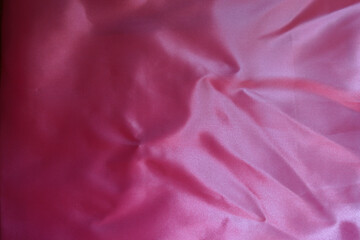 cold pink satin polyester fabric with wrinkles