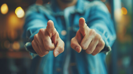person in a denim jacket is pointing directly at the camera, with the focus on the pointing finger and the background blurred. - obrazy, fototapety, plakaty