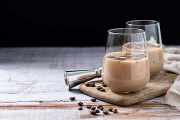 Traditional Irish cream coffee liqueur with ice on wooden table. Copy space