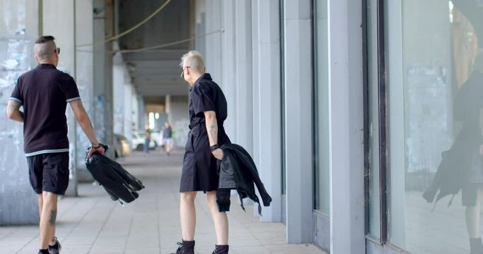 Couple strolls through the city. Active communication suggests dynamic interaction with urban surroundings, embracing punk spirit of freedom and self-expression. 30.9.23. Prague, Strachov