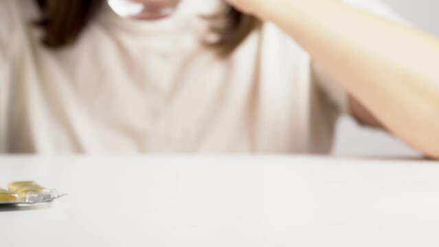 Woman showing a pill and take it. Food supplement oil filled. Capsules with omega 3, fish oil.