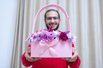 a young male is holding pink roses, gifting them on Valentine's Day and Mother's Day