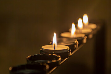Lit tea lights in a church, with a shallow depth of field