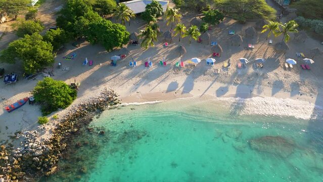 High angle overview of whitewash waves crashing on luxurious tropical Caribbean paradise shoreline