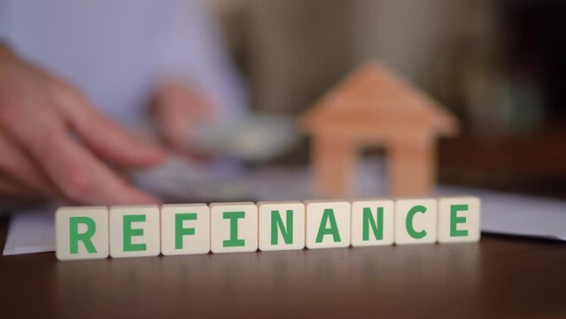 Person refinancing a mortgage on a property. Real estate refinance concept. Selective focus with man counting cash in the background.