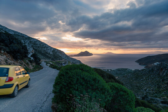 Car driving on the road in the mountains over Agean