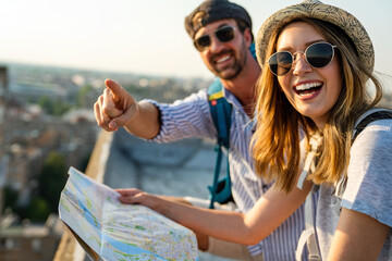 Happy couple on vacation sightseeing city with map. People travel fun honeymoon concept. © NDABCREATIVITY