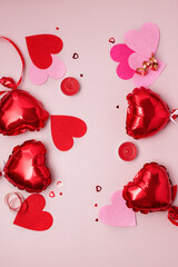 St Valentine's Day concept Top view photo of heart shaped shiny red balloons and confetti on pastel pink background