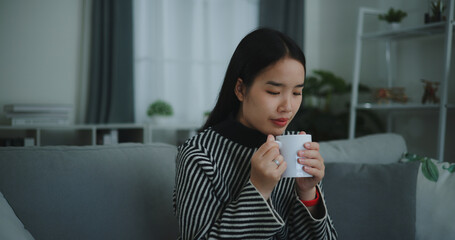 Portrait of Relaxing young woman holding cup enjoy smell coffee or tea and drinking with happiness...
