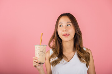 Asian woman holding drinking brown sugar flavored tapioca pearl bubble milk tea lick lips wanna taste have delighted summer holiday dream, smile female, isolated on pink background, beverage concept - obrazy, fototapety, plakaty