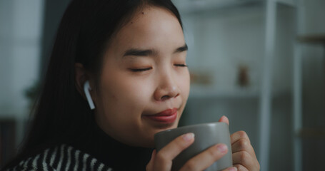 Portrait of Happy young asian woman enjoy listening to the music with wireless headphones while...