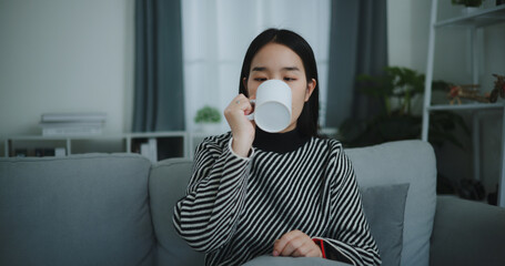 Portrait of Relaxing young woman holding cup enjoy smell coffee or tea and drinking with happiness...