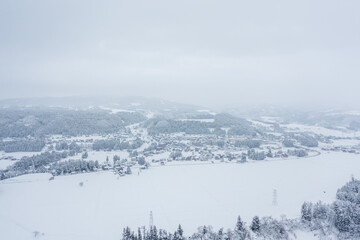 ドローン撮影：真っ白な雪に覆われた田舎町の風景