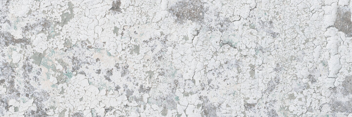 Peeling paint on the wall. Old concrete wall with cracked flaking paint. Weathered rough painted surface with patterns of cracks and peeling. High resolution texture for background and design. Closeup