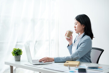Portrait of beautiful business asian woman in blue suit working office desk computer. Small business sme . - obrazy, fototapety, plakaty