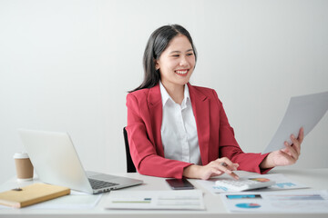 Portrait of smile beautiful business asian woman in red suit working office desk computer. Small business sme .