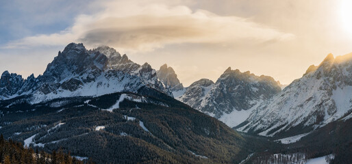 The sharp ridges of the Tre Cime mountain range and UNESCO World Heritage site before a winter sunset.  - obrazy, fototapety, plakaty