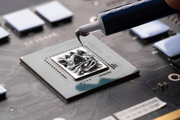 Applying thermal paste to a computer processor. Processor installation concept and cooling solution. Applying thermal paste during CPU installation close up in the motherboard.
