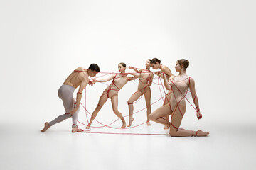 Elegant female ballet dancers pulling man with red strings symbolizing affection and control...