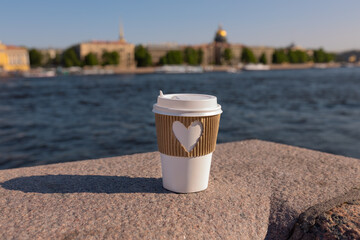 cup of drink coffee on bridge near embankment of Neva river in St. Petersburg, summer day