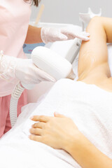 Fototapeta na wymiar Armpits laser treatment. Close up shot of a young woman having armpits hair removed with a laser hair removal machine by a professional beauty therapist at the beauty spa salon depilation epilation