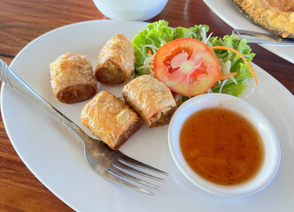 chopped crispy deep fried Tofu Skin Rolls With Crab meat, called in thai as Hoi Jo Pu served with Sweet and Sour Plum Sauce