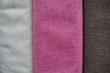 hand touches fabrics of different colours and textures