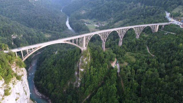 Aerial view of cars on Durdevica Tara Bridge with a river below in Zabljak Canyon