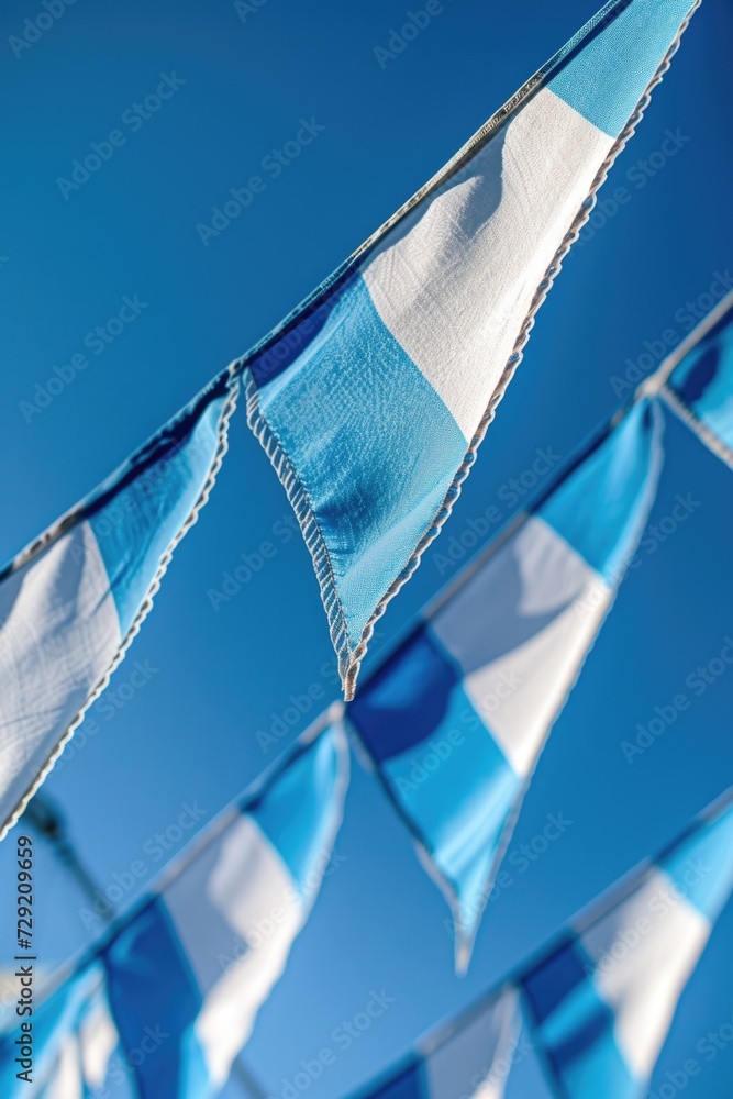 Poster a picture of a bunch of blue and white flags hanging from a line. this versatile image can be used t