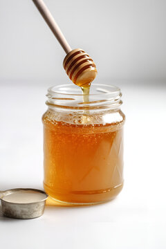 Glass jar full of honey and wooden dipper on white background, Generative AI