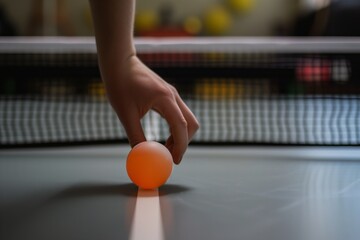 hand picking up ping pong ball from the floor, table in background - obrazy, fototapety, plakaty