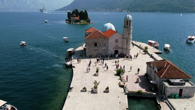 Drone view of people visiting Church of our lady of the rocks in St. George's Island near Perast