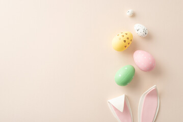 Festive egg hunt admirer setting. A top view captures lively eggs in flight, accompanied by tucked-away bunny ears on a pastel beige surface, offering space for messages or ads