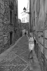 Fototapeta na wymiar a woman standing on a street corner in a black and white photo