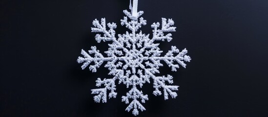 Handcrafted New Year ornament: white snowflake on black backdrop.