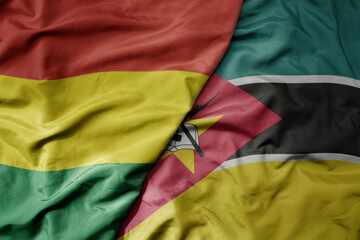 big waving national colorful flag of mozambique and national flag of bolivia .