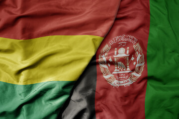 big waving national colorful flag of afghanistan and national flag of bolivia .