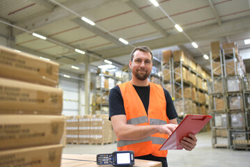 portrait of friendly warehouse worker in a forwarding agency - interior with forklift - transport and storage of goods