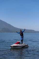 Young Hispanic Man Stands on Jet-Ski at Atitlan Lake, Guatemala