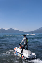 Naklejka premium Two Young Hispanic Men Riding Jet-Skis in Atitlan Lake, Guatemala