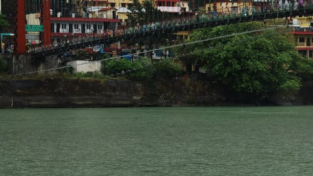 People crossing Ram Jhula/ Bridge during rainy season in Rishikesh/ Haridwar, India.