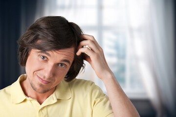 Pensive sad young man at home