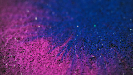 Ink drop. Paint splatter. Defocused blue pink color wet stain blotch spreading motion on grain bokeh light texture abstract background reveal effect.