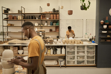 African potters working at benches in a large ceramics studio