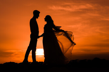 silhouettes Man and woman against the backdrop of sunset, lovers, intimacy