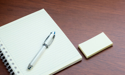 a notebook with a pen and self-adhesive paper