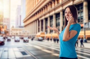 Fototapeta premium Young woman using modern smartphone at street