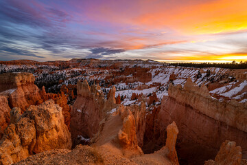 Fototapeta na wymiar Sunset Bryce canyon national park in winter, unique rock formations in utah covered in snow, orange rocks in snow, cold winter in the usa