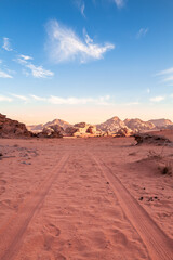 Wadi Rum, Jordan, Scenic view of Arabic Middle Eastern desert against clear blue sky with sand tracks in foreground. Mountain in background. Copy space no people