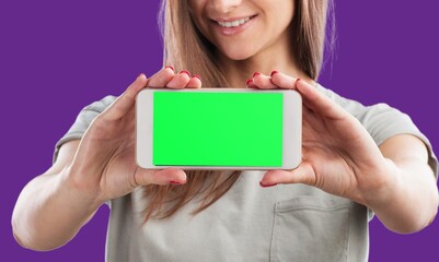 Young happy woman demonstrates blank screen phone